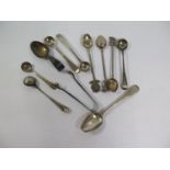 A pair of antique silver sugar tongs, a teaspoon, various salts, a feeding spoon, and other spoons