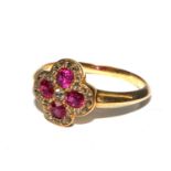 A gold ring set with diamonds and pink stones, possibly rubies