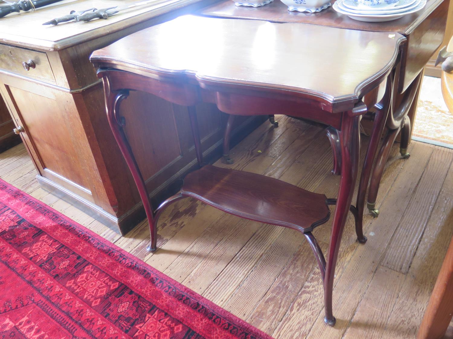An Edwardian mahogany fold over card table, the shaped top over cabriole legs joined by an
