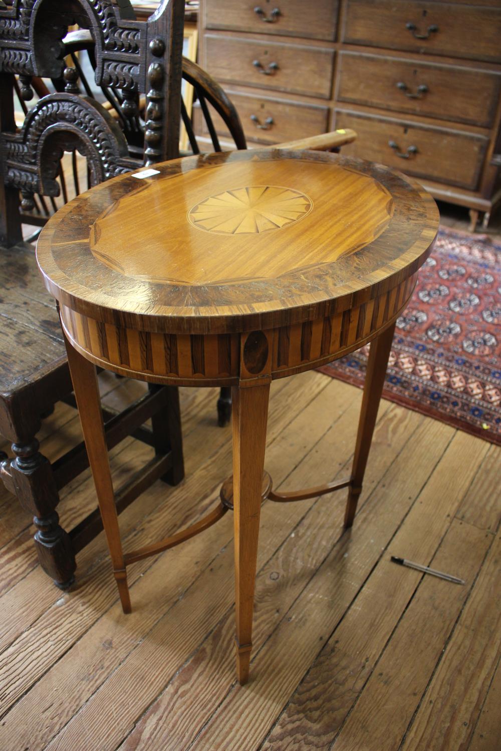 An Edwardian inlaid oval window table, the patera inlaid and crossbanded top over an inlaid