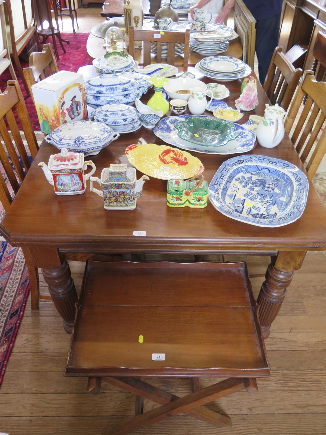 An Edwardian walnut extending dining table, with one leaf, on turned reeded legs and castors, five