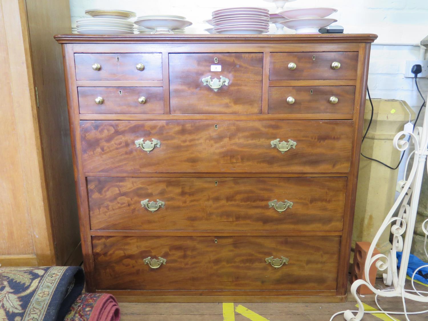 A late 19th century mahogany chest of drawers, stamped Edwards & Roberts, with one deep short drawer