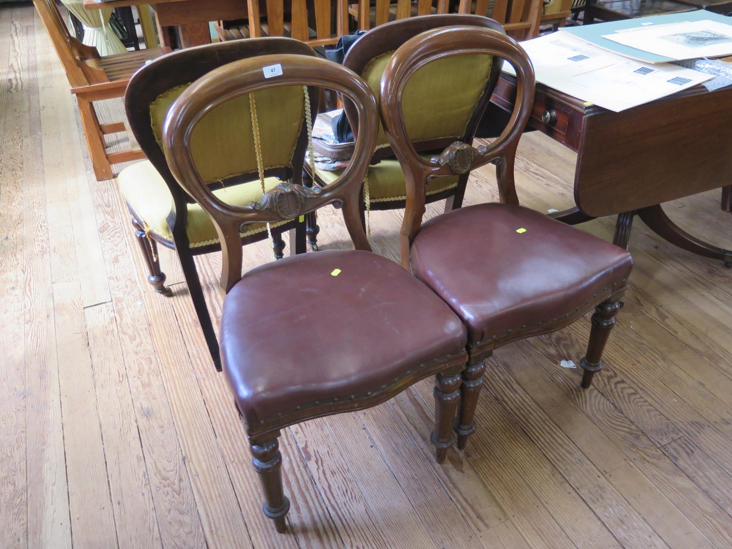 A pair of Victorian balloon back dining chairs, with overstuffed seats on turned tapering legs (2)