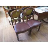 A pair of Victorian balloon back dining chairs, with overstuffed seats on turned tapering legs (2)