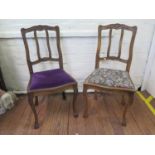 A pair of French walnut dining chairs, the foliate carved rail backs over drop in seats on carved