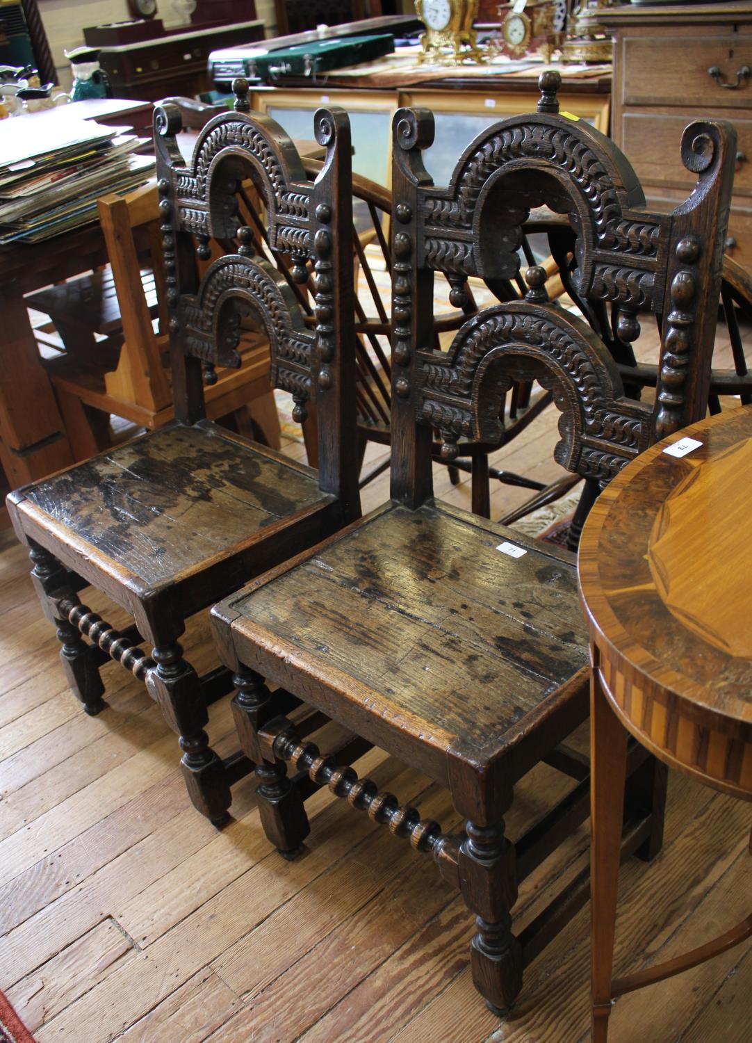 A pair of Yorkshire or Derbyshire backstool chairs, carved arched back rails with pendants over