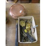 A copper warming pan and various horse brasses