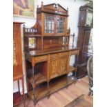 An Edwardian inlaid rosewood side cabinet, the broken triangular pediment over a pair of bevelled