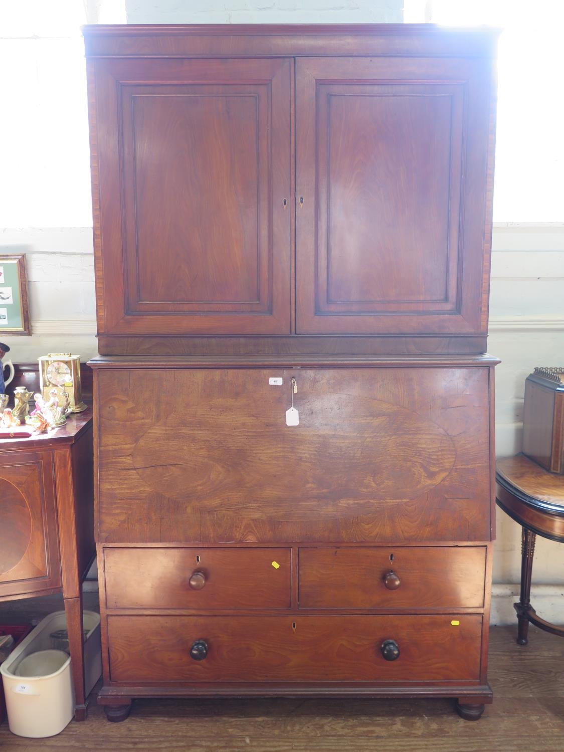 An early 19th century mahogany secretaire cabinet, the pair of panelled doors enclosing adjustable