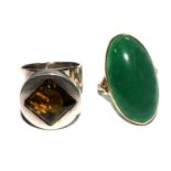 A 9 carat gold ring set with a large green stone together with a silver and an amber ring