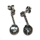 A pair of white gold earrings set with diamonds and aquamarines