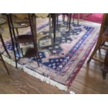 An Caucasian rug, with three ivory medallions on a grey red and blue field within multiple