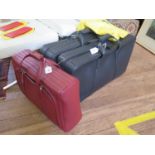 A Ferrari red leather suitcase, by Schedoni, with dust cover, 52 x 39 x 16 cm, and a pair of black