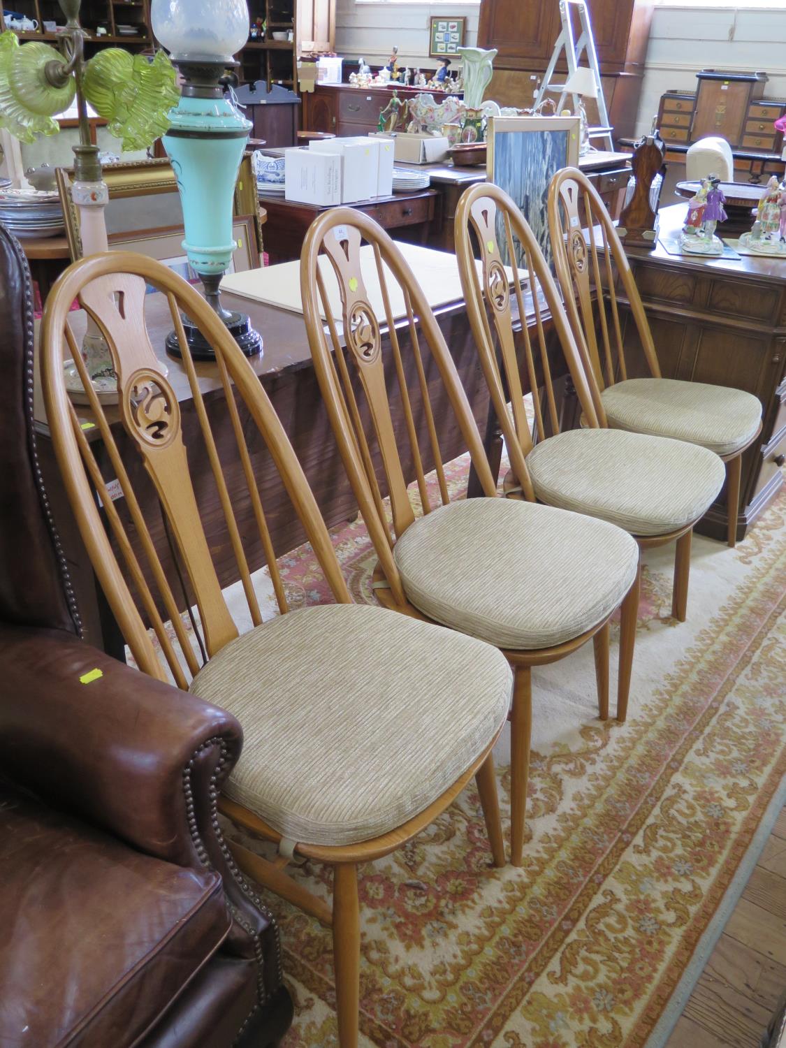 A set of four Ercol ash Windsor type dining chairs, the splats with pierced carving of swans (4)