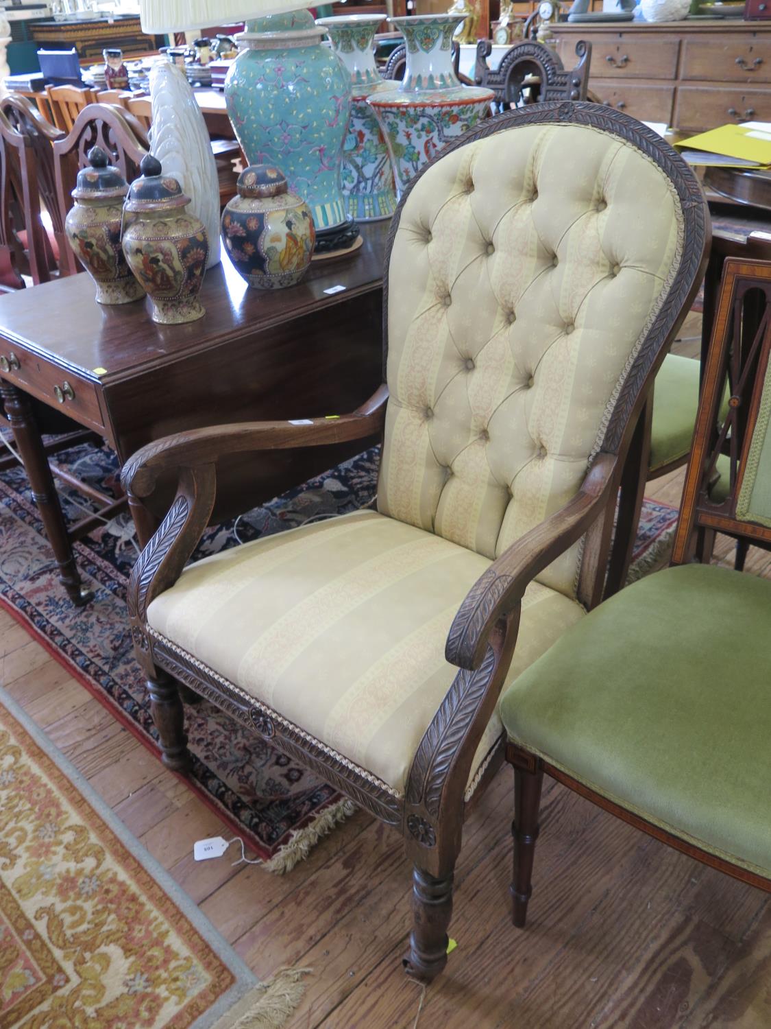 A Victorian hardwood open armchair, carved throughout with a leaf design, the arched button back