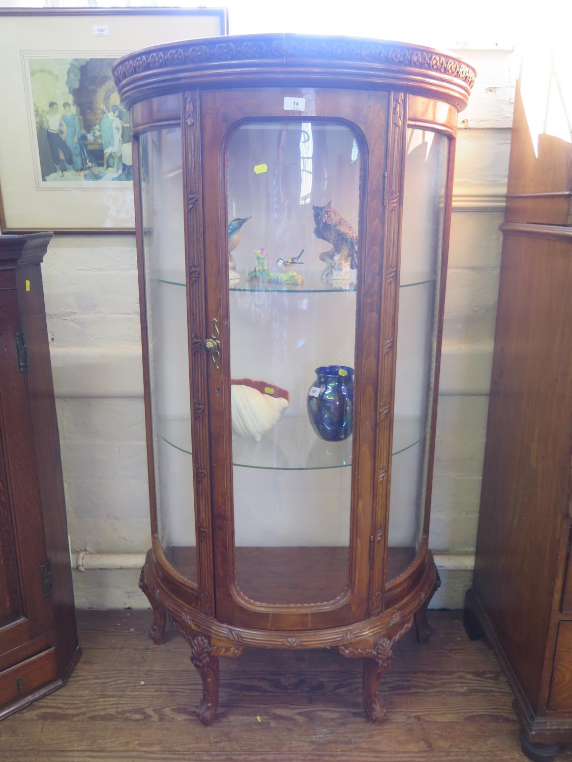 A French style stained beech demi-lune display cabinet, with single glazed door over foliate