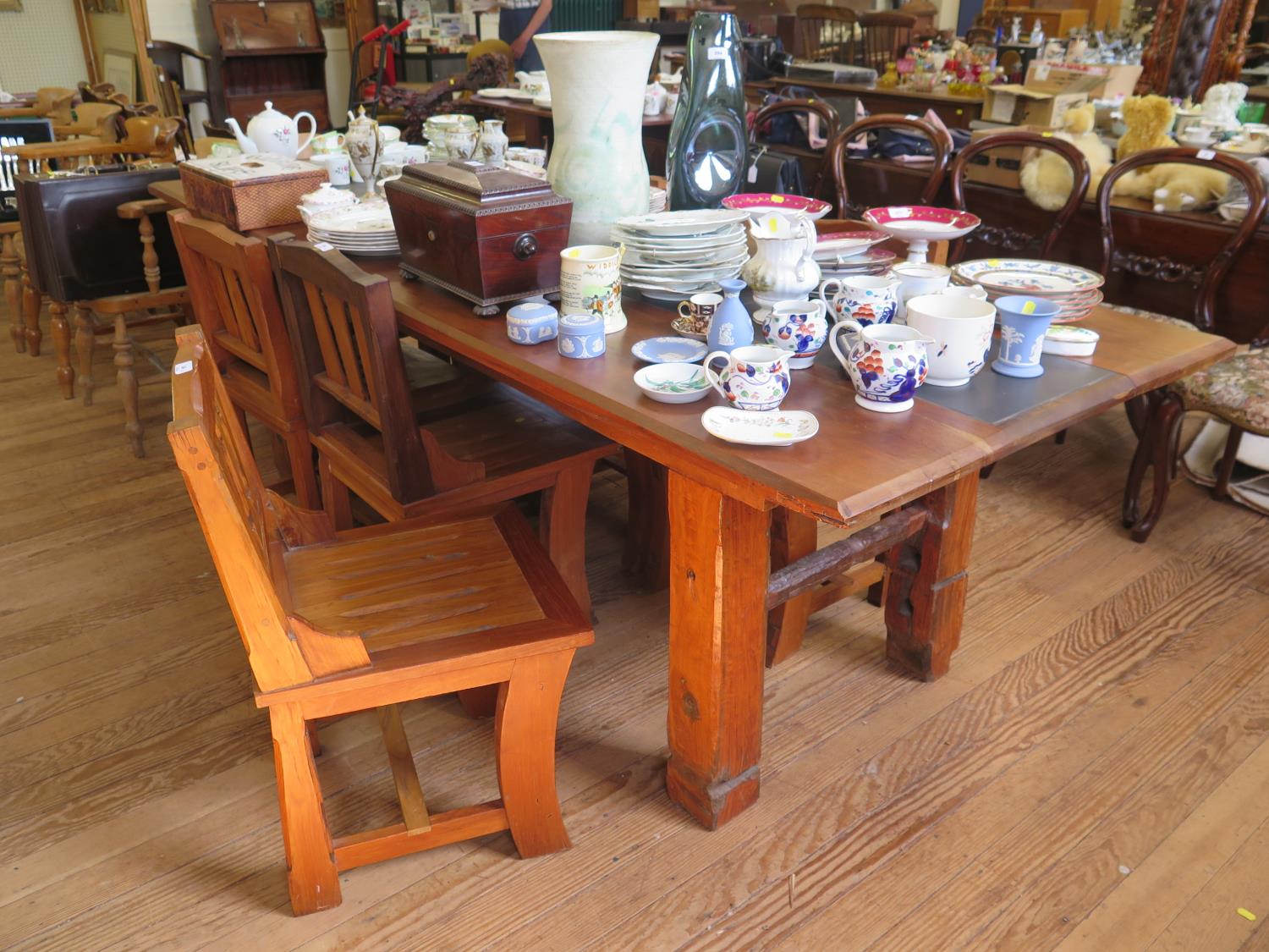 A hardwood dining table and seven dining chairs, in the rustic style, the table top inset with