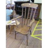 An ash and elm kitchen armchair, the broad top rail over turned spindles and moulded seat on ring