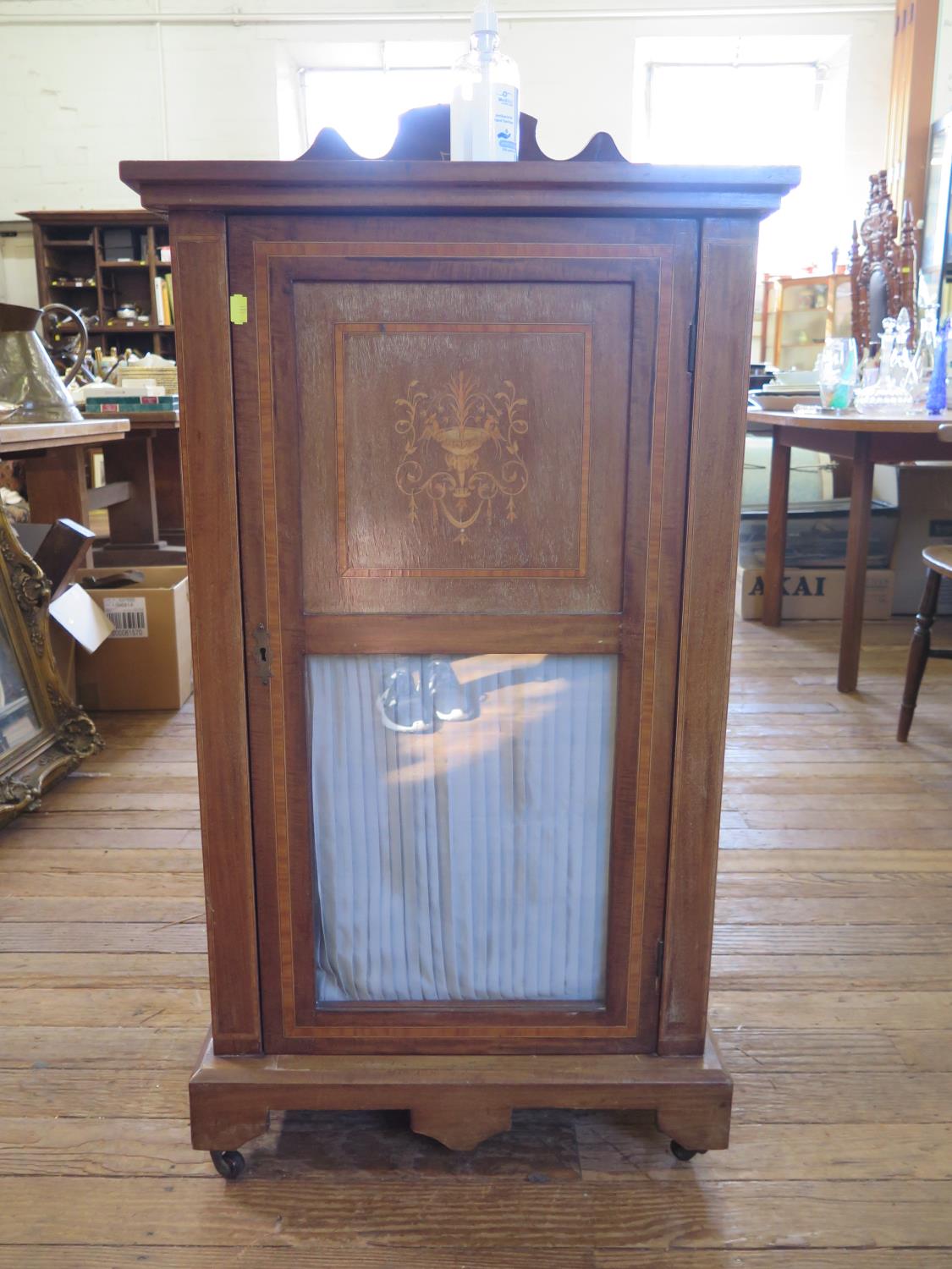 An Edwardian mahogany and satinwood crossbanded music cabinet, the raised back over a glazed and