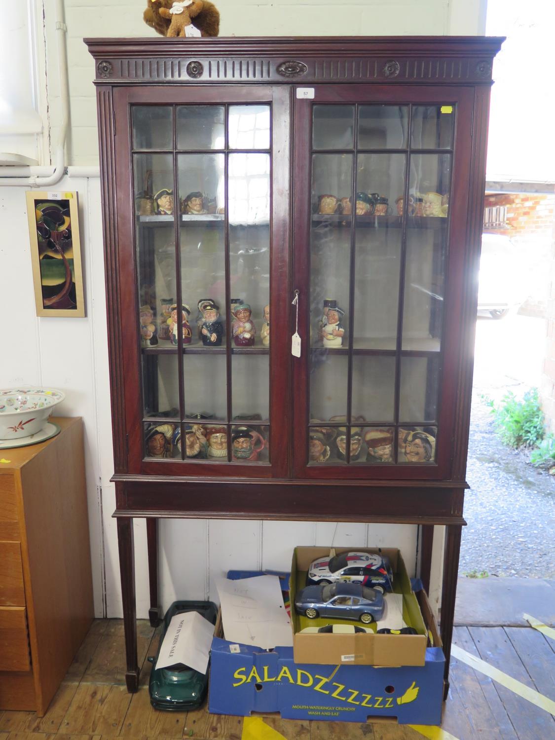 An Edwardian mahogany display cabinet, the fluted and rosette frieze over a pair of glazed doors