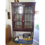 An Edwardian mahogany display cabinet, the fluted and rosette frieze over a pair of glazed doors