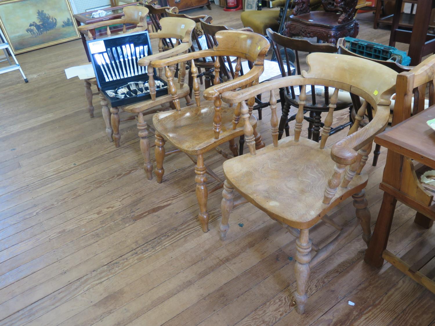 A set of four ash and elm Captain's armchairs, with baluster turned spindles over moulded seats