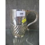 A silver mug of half ribbed form