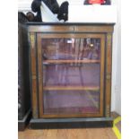 A late Victorian ebonised and walnut side cabinet, the patera inlaid frieze over a glazed door