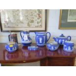 Wedgwood dark blue jasperwares, including two jugs, a teapot, and boxes, all with Classical figures,