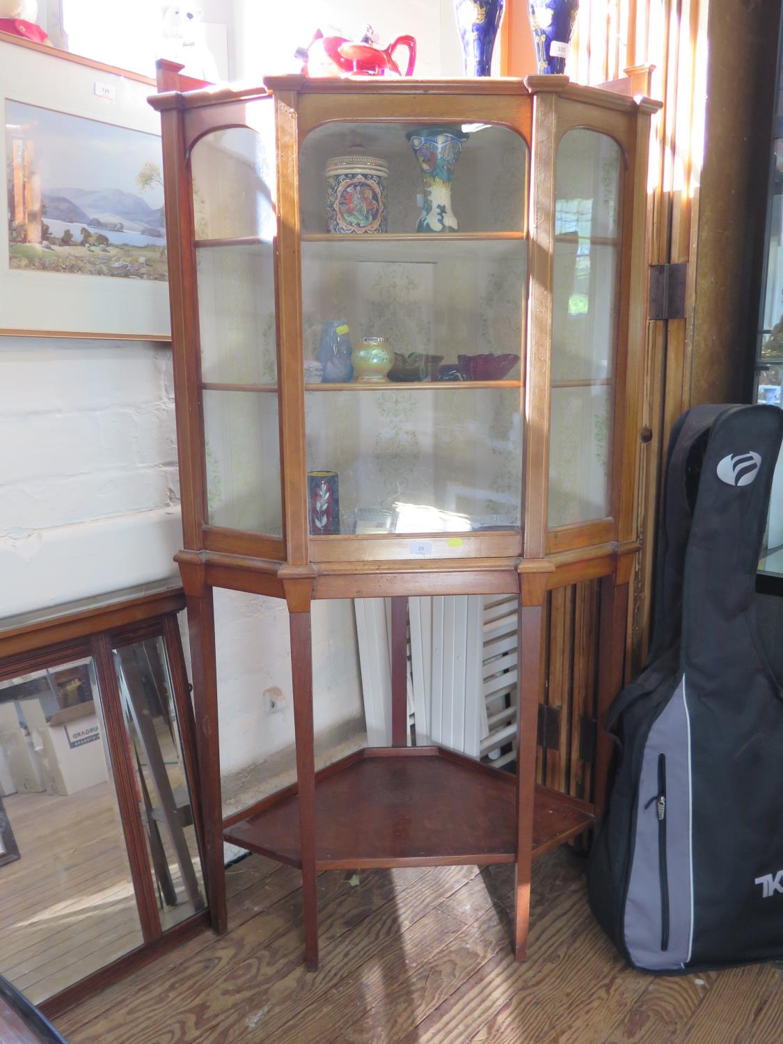 An Edwardian inlaid mahogany corner display cabinet, the raised back over a glazed door, on long