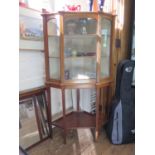 An Edwardian inlaid mahogany corner display cabinet, the raised back over a glazed door, on long