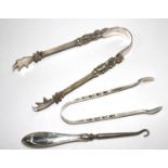 A pair of Victorian sugar nips, a smaller pair of sugar nips and a button hook with silver handle