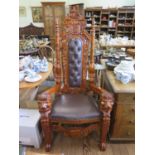 A carved Oriental hardwood throne type chair, the button upholstered back with carved shield