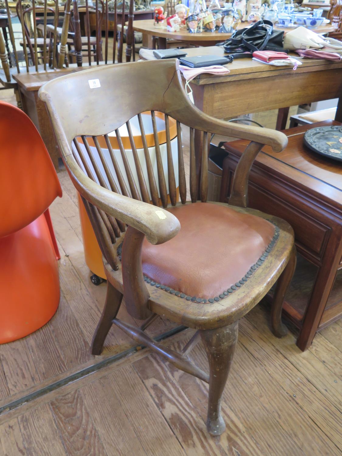 A 1930s spindle backed office chair, on cabriole legs with pad feet and stretchers