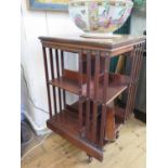 A mahogany revolving bookcase, with slat sides on a cross frame base, 50 cm square, 85 cm high