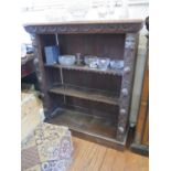 A Victorian carved oak open bookcase, with lunette frieze above lion head and fruit carved supports,