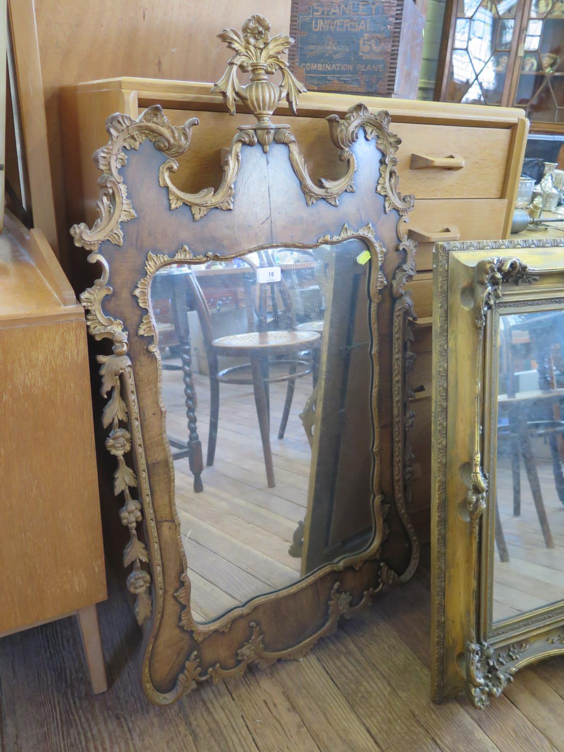 A George I style parcel gilt walnut wall mirror, with scrolling surround and vase form surmount, 107