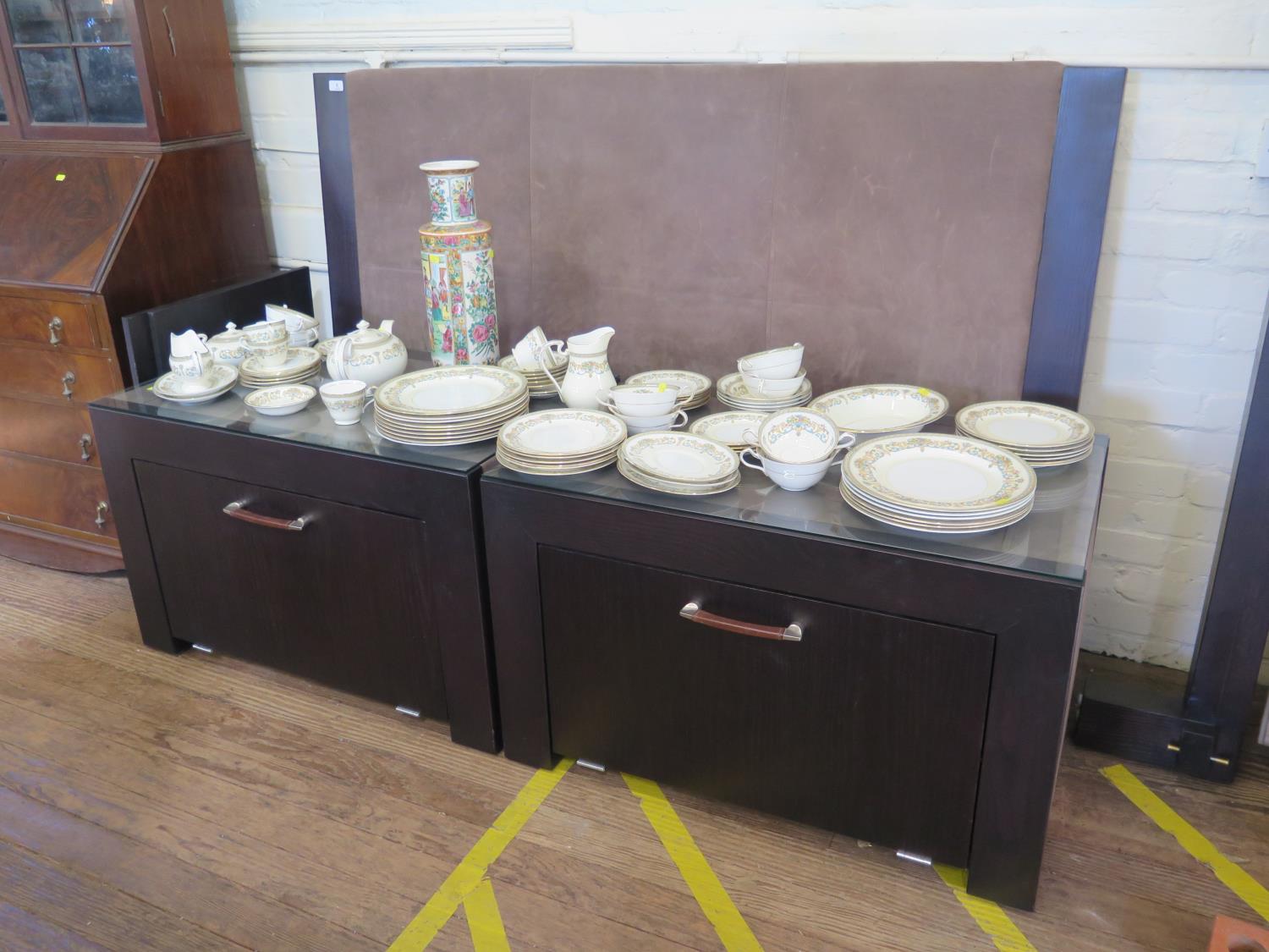 A pair of Rebecca Scott ebony finish and suede bedside tables, with fall front cupboards, 90 cm