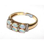 A yellow half hoop ring, the double barrel wire claw head set with opals and round brilliant cut