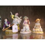 Three porcelain figures of children on a seesaw, playing with rabbits and a shepherdess with a sheep