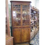 A George III elm corner cabinet, the moulded cornice over a pair of glazed doors enclosing shaped