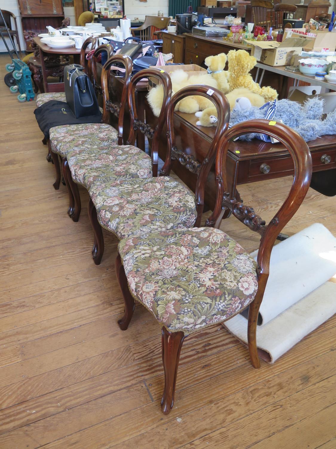 A set of six Victorian mahogany balloon back dining chairs, with scroll carved mid-rails,