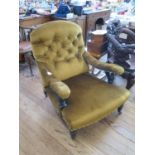 A Victorian ebonised button back deep armchair, with curved arms, turned supports and legs on pot