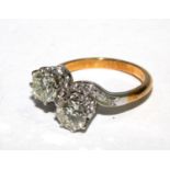 A ladies two stone diamond crossover ring set in gold coloured metal
