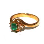 An 18ct ladies ring set with trap cut emerald and diamonds