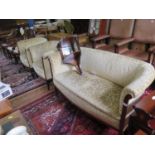 An Edwardian mahogany three piece suite, with upholstered backs, arms and seats, on patera and