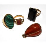 Three rings to include a malachite set ring and an amber pendant