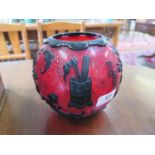 A 20th century Chinese cameo glass globular vase, in red overlaid in black, depicting vases of