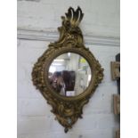 A giltwwod convex wall mirror, the circular plate within a scroll and rose carved frame, 62 cm high,