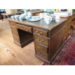 An oak pedestal desk, the inset top over three frieze drawers above pedestals each with three